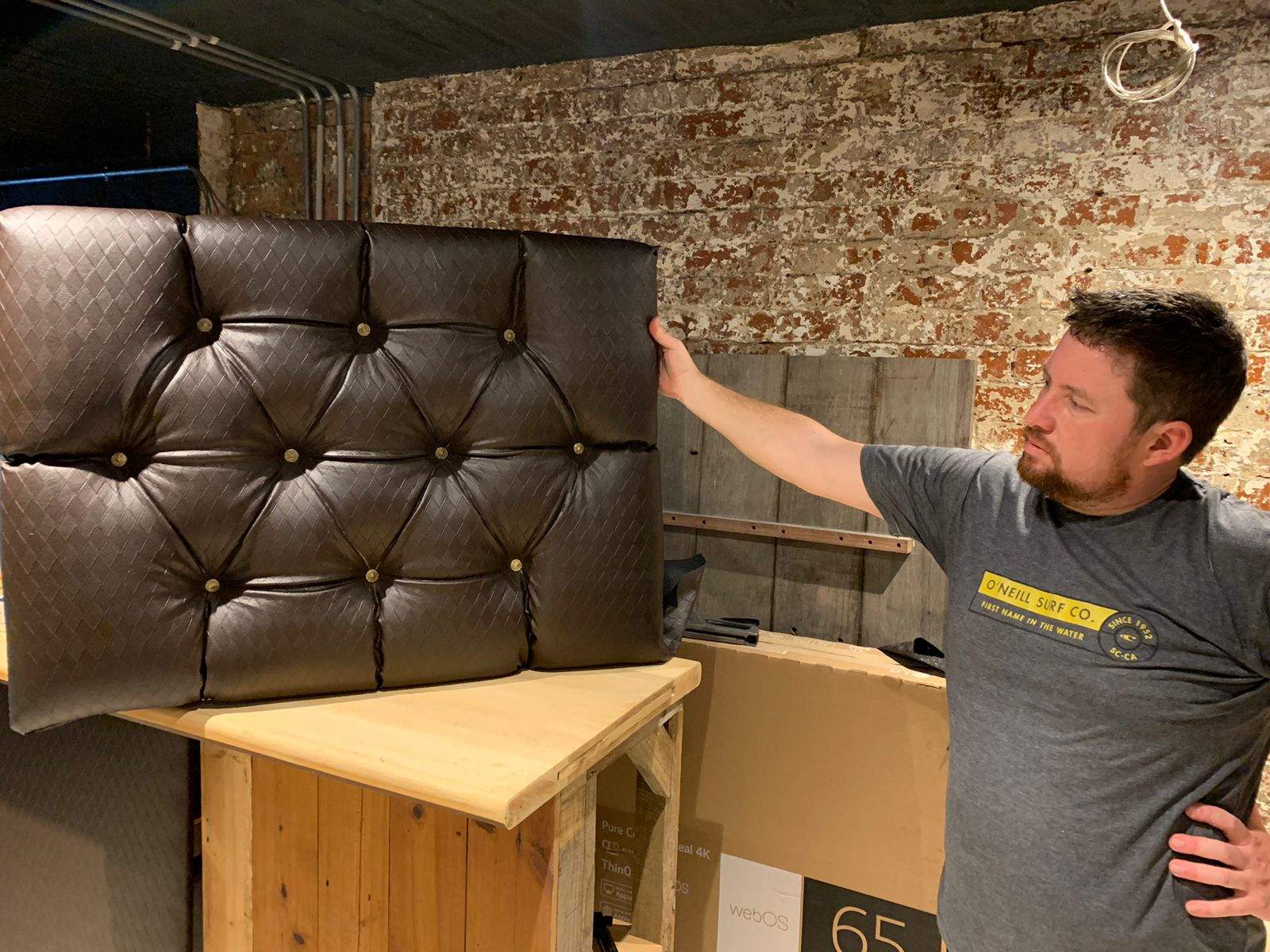 David checking the custom diamond-pattern couch upholstery during the showroom build